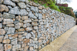 Ein Zaun aus Steinen an einer Straße zum Lärmschutz